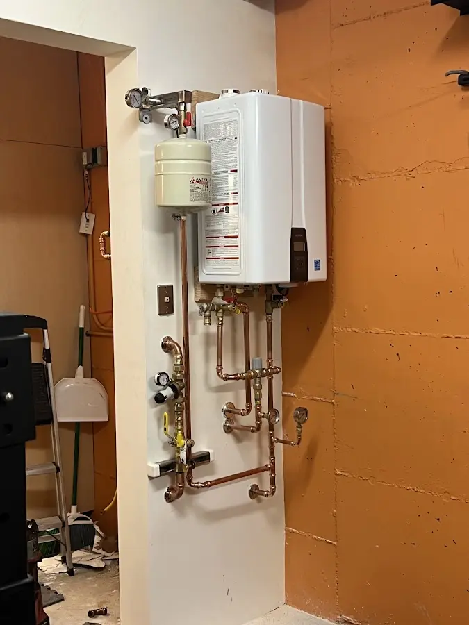 Plumbing technician inspecting water heater connections in Long Grove